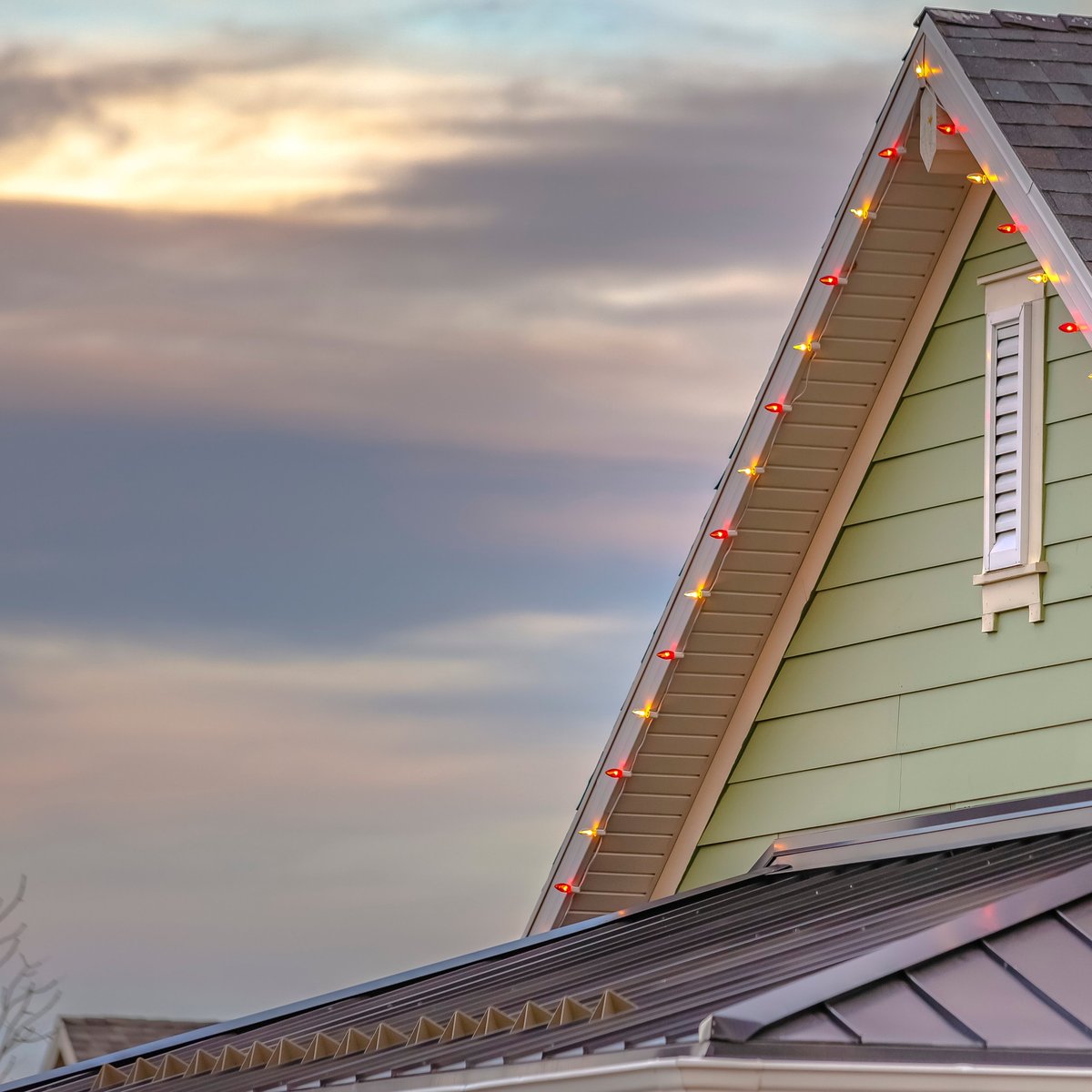 Govee permanent colored LED lighting illuminating house roofline at sunset