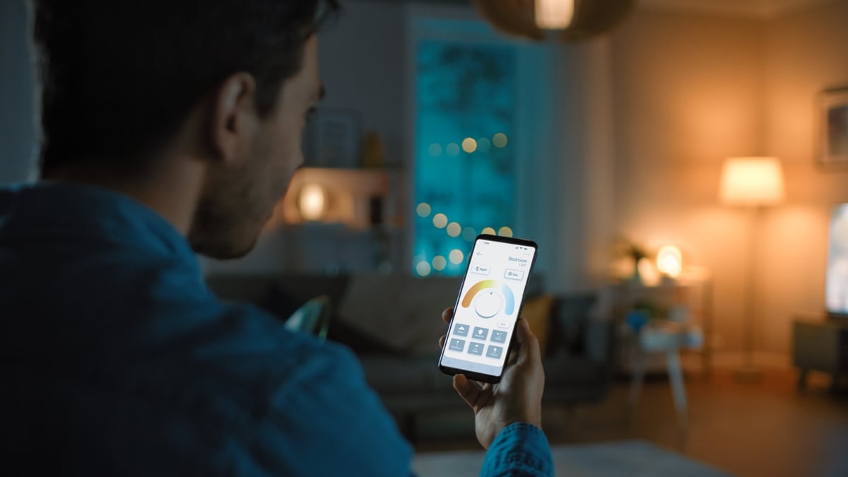 Man gives a voice command to a smart home app to change light temperature