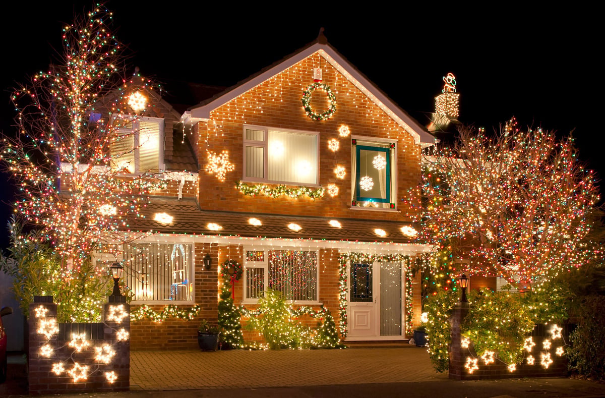 Christmas lights outside on a house and in the garden