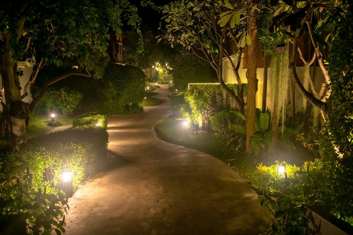 Footpath alley with lamp decoration by trees in the park at night