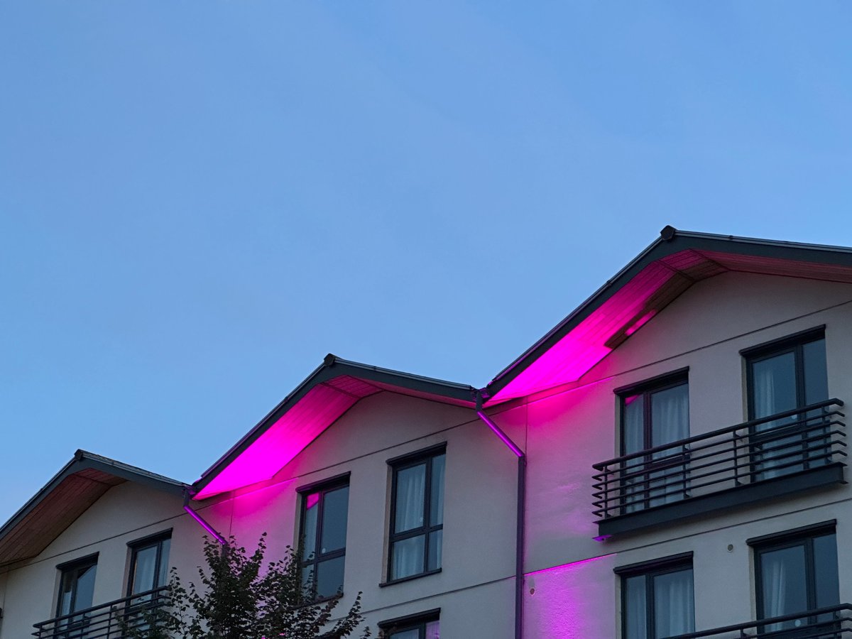 Govee pink neon LED exterior lighting on a modern building at night