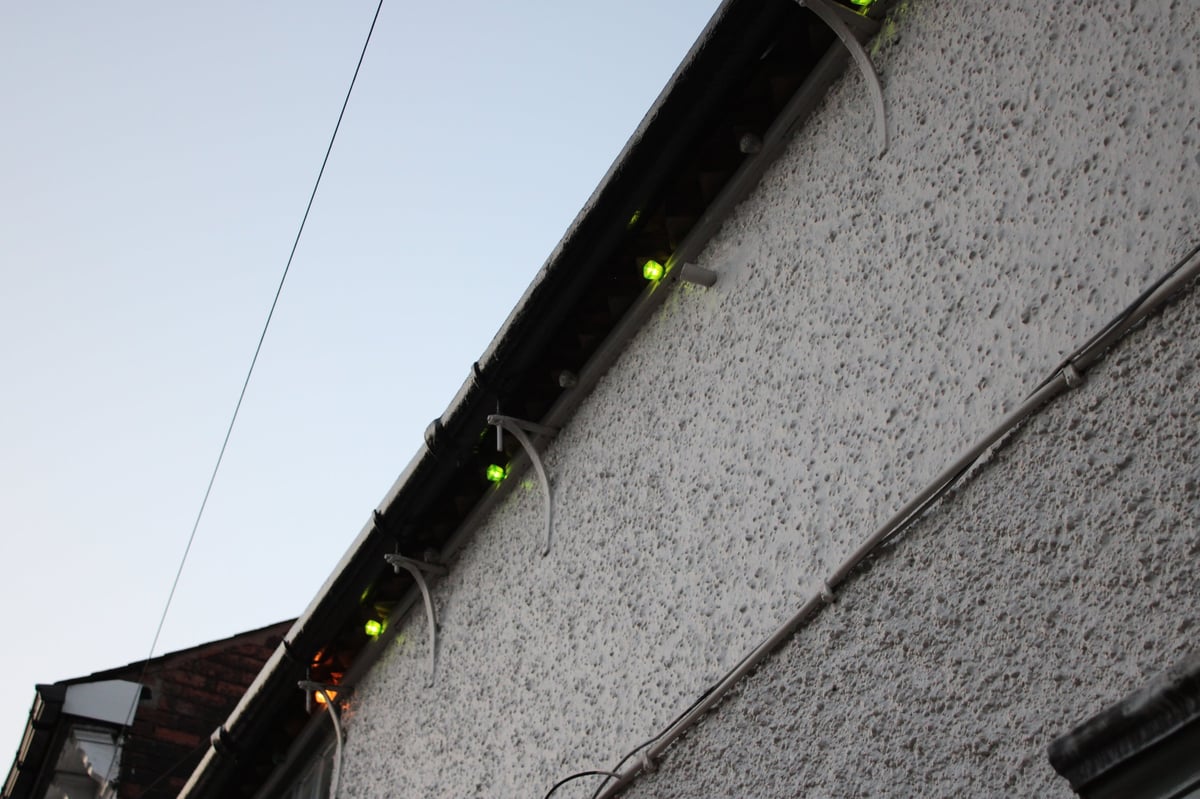 Low angle picture of side of rendered building with outdoor lights attached