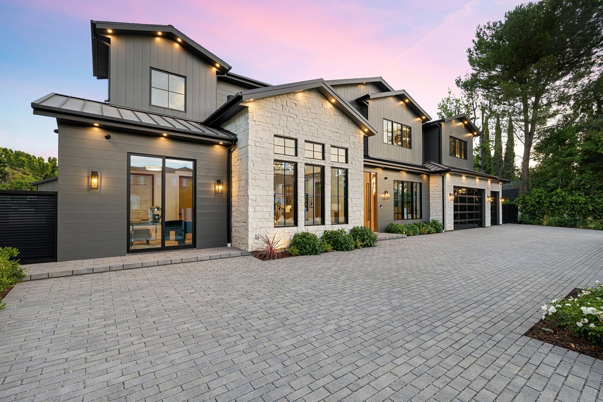 Modern luxury home exterior with large windows and Govee lighting at sunset