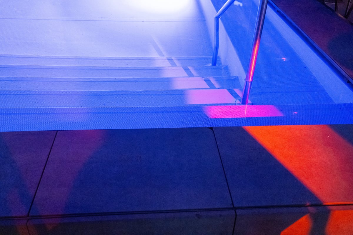 Modern swimming pool illuminated with purple lights at night