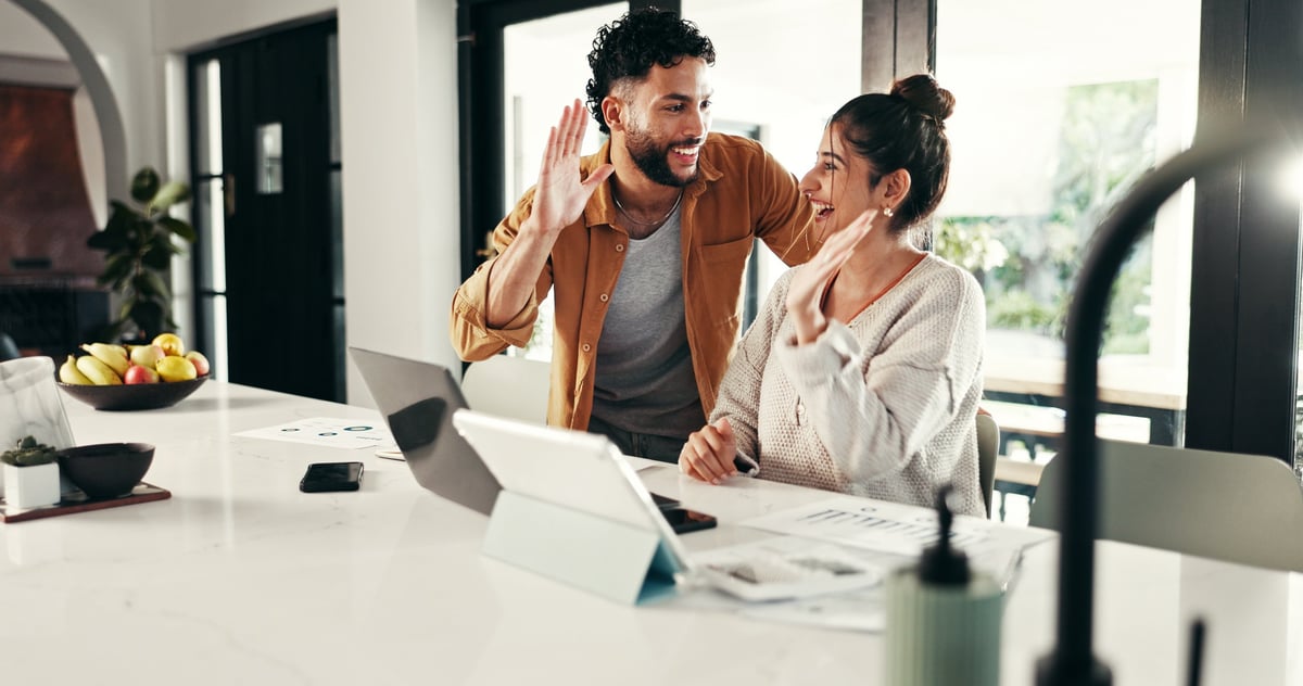 Happy couple celebrating with a high five at home customer review