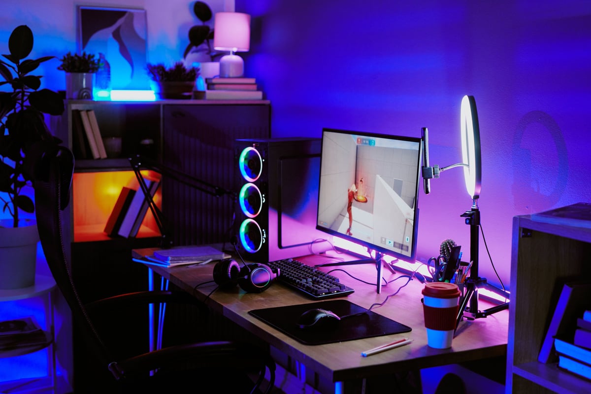 Modern home gaming setup with RGB lighting, large monitor displaying video game