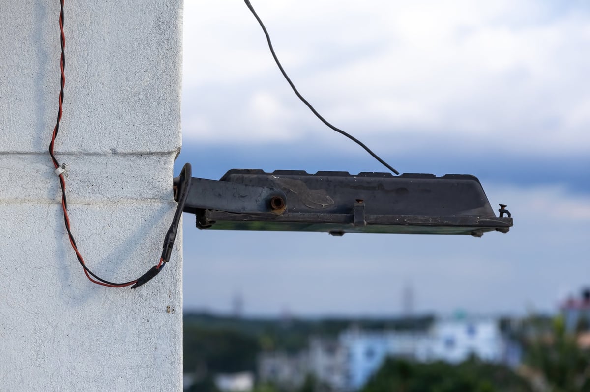 Modern outdoor LED lighting fixture mounted on a building wall below the roofline