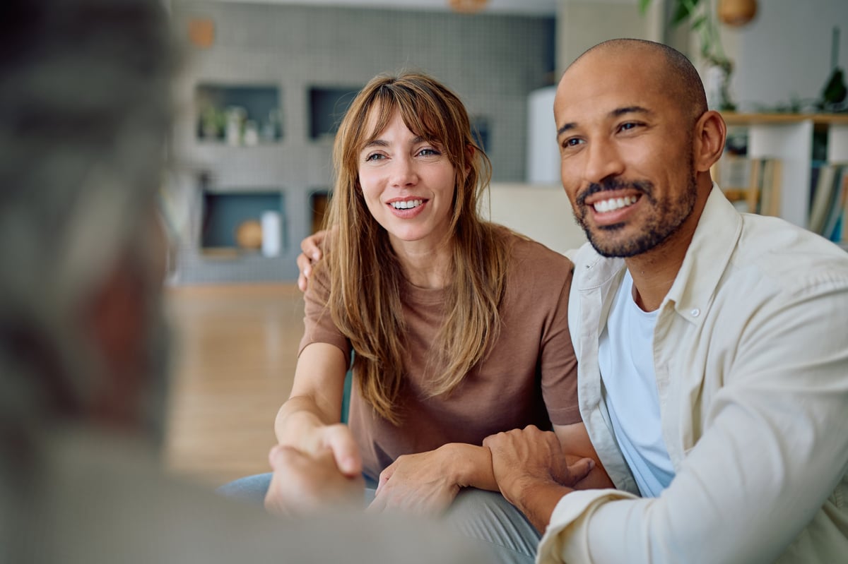 Young couple smiling and shaking hands with a consultant customer review
