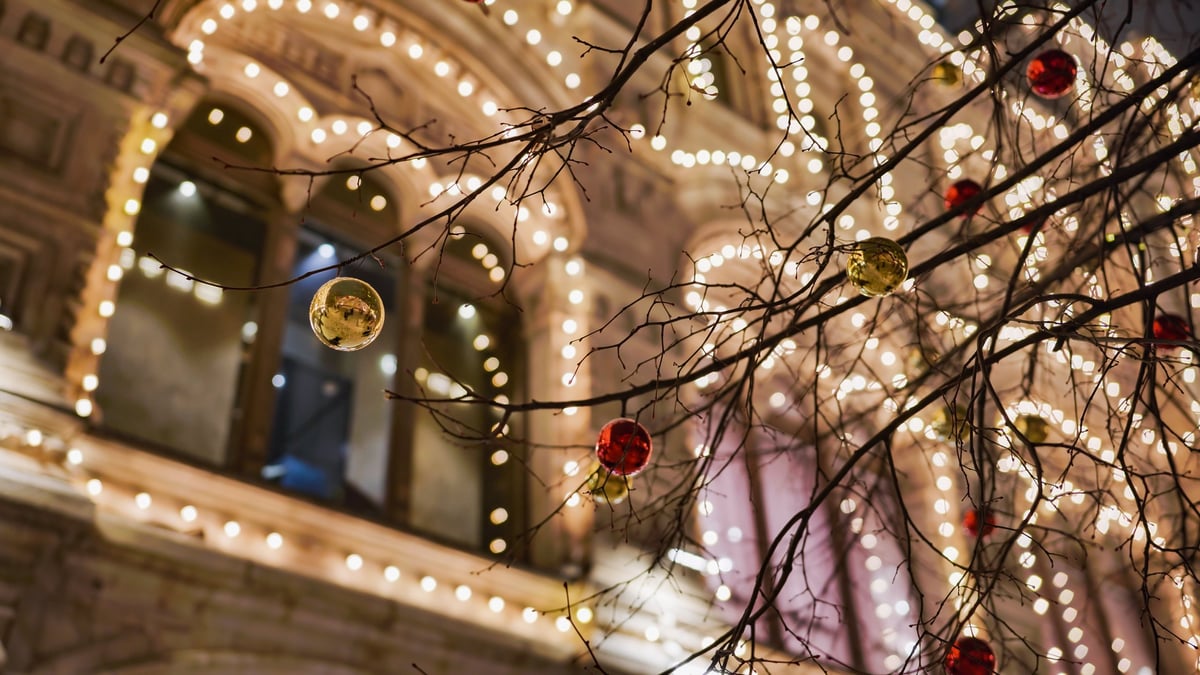 Glowing Christmas lights and colorful baubles decorating a building facade