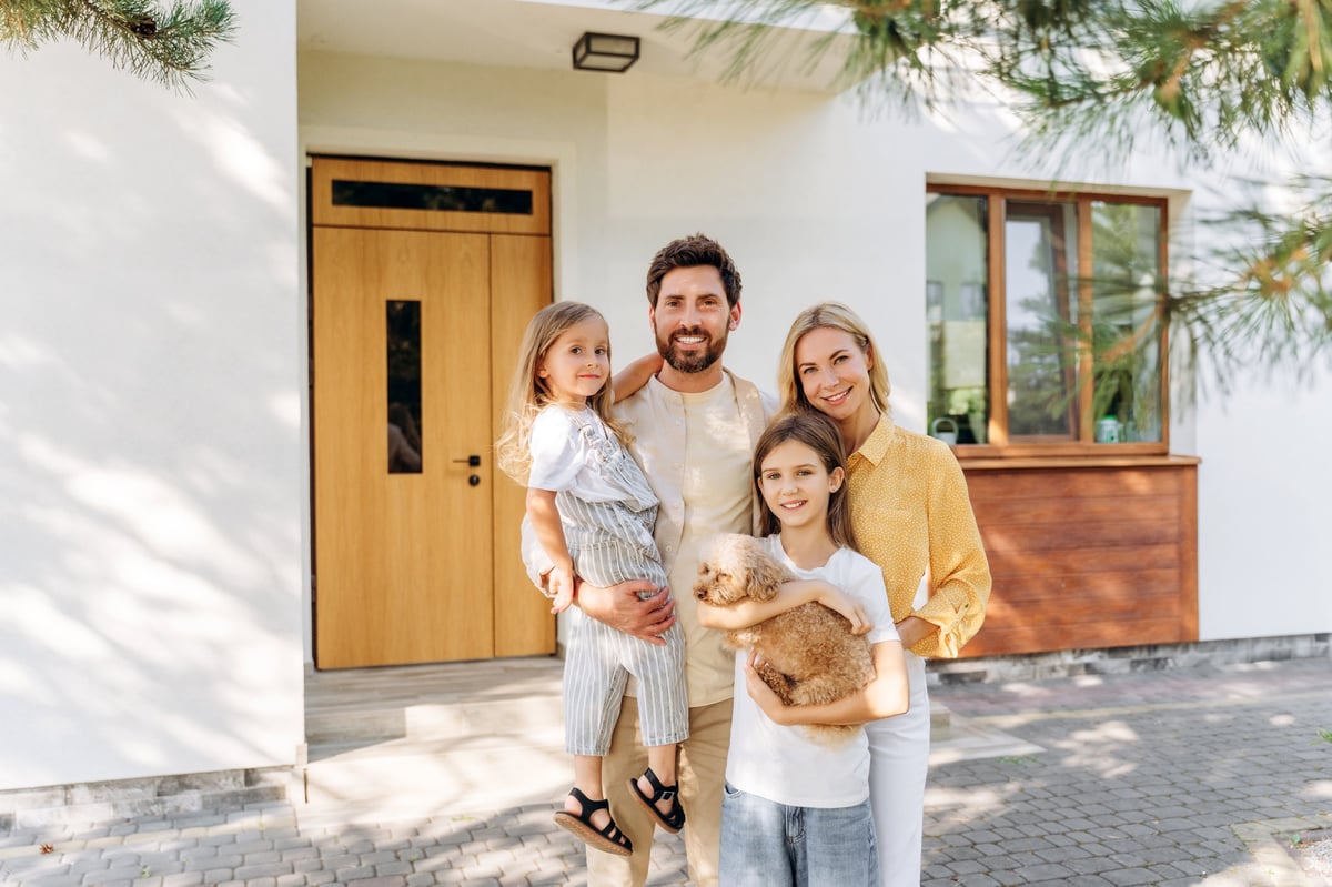 Happy family with two daughters posing together at their home