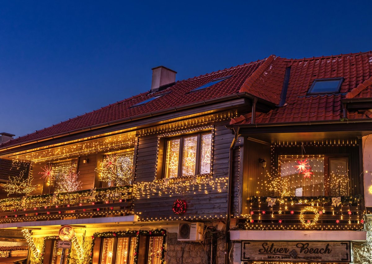 A charming house decorated with warm Christmas lights during the evening