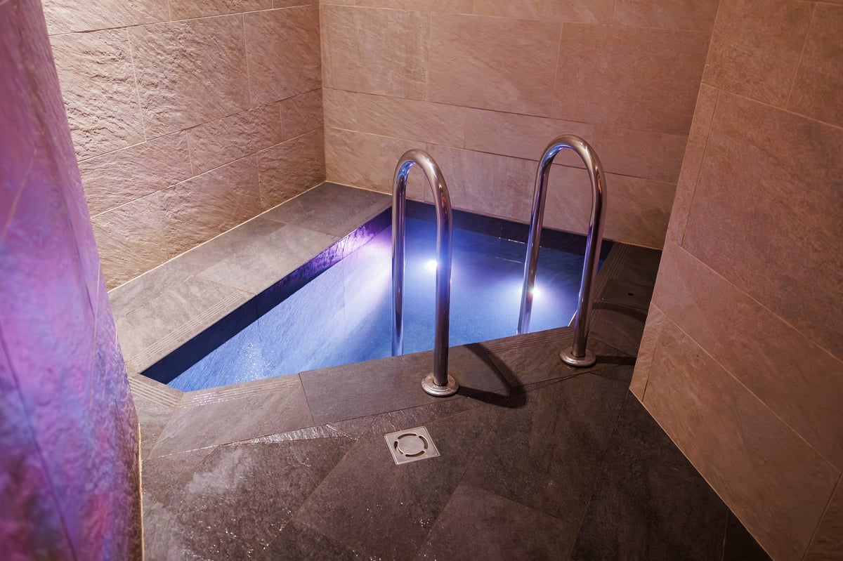 Compact tiled plunge pool with cool white and violet underwater LEDs