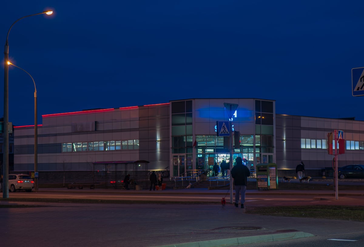 Building with red roof LEDs and warm streetlights in the evening