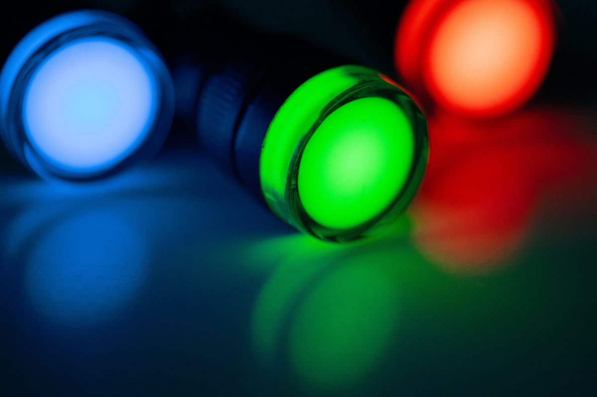 Close-up of red, green and blue LED indicator lights on dark background
