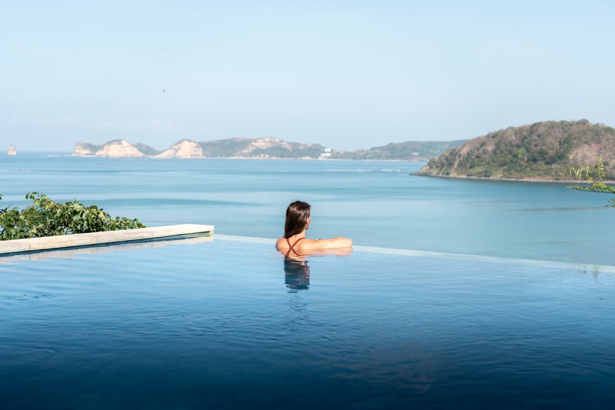 Woman relaxing in a beautiful illuminated infinity pool