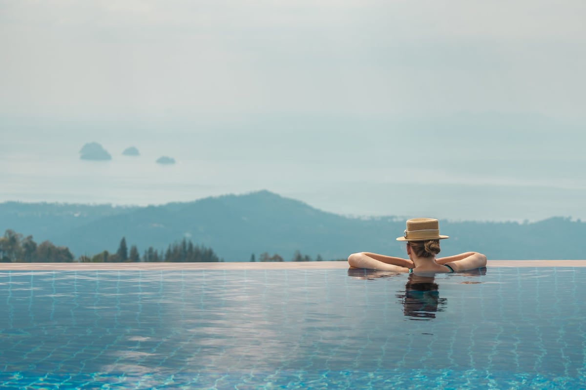 Relaxing in an infinity pool overlooking misty mountains with fresh water