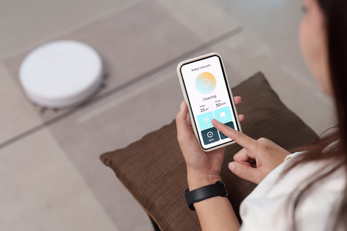 Woman uses her smartphone to manage smart home technology