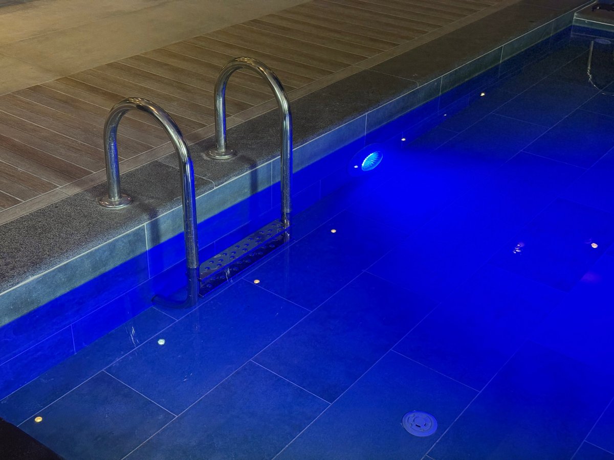 Illuminated pool at night with serene blue underwater lighting
