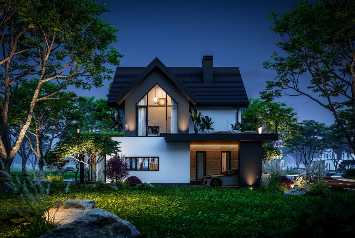 Modern Scandinavian style family home with dramatic exterior lighting and garden landscaping at twilight