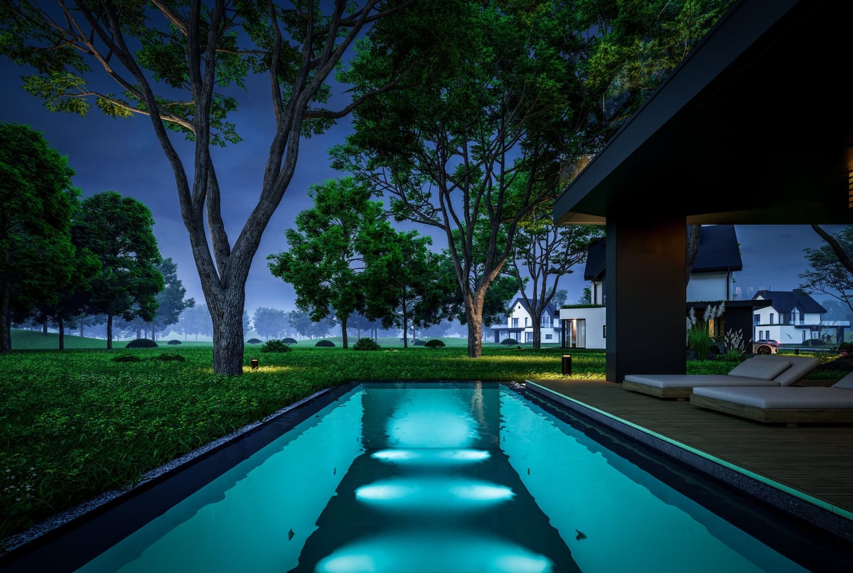 Contemporary luxury house exterior with dramatic lighting and garden at night